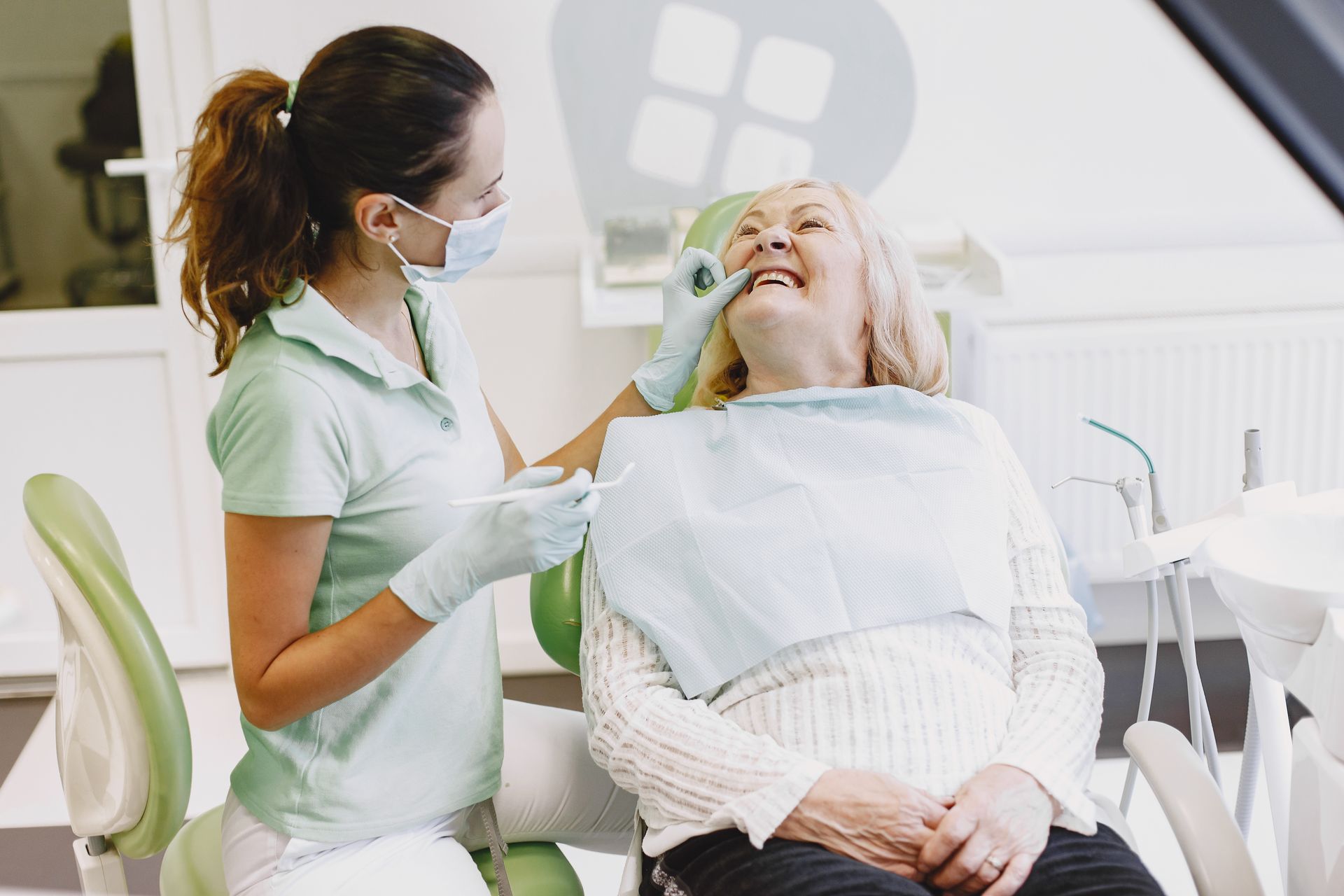 A smiling patient laughing with a Marigold Dental hygienist during a relaxed checkup
