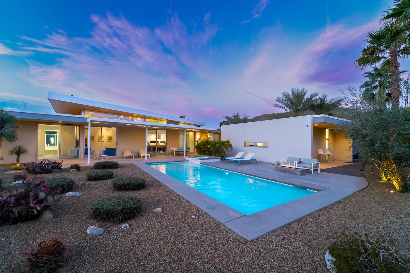 Modern Arizona desert home at twilight with a cool blue pool