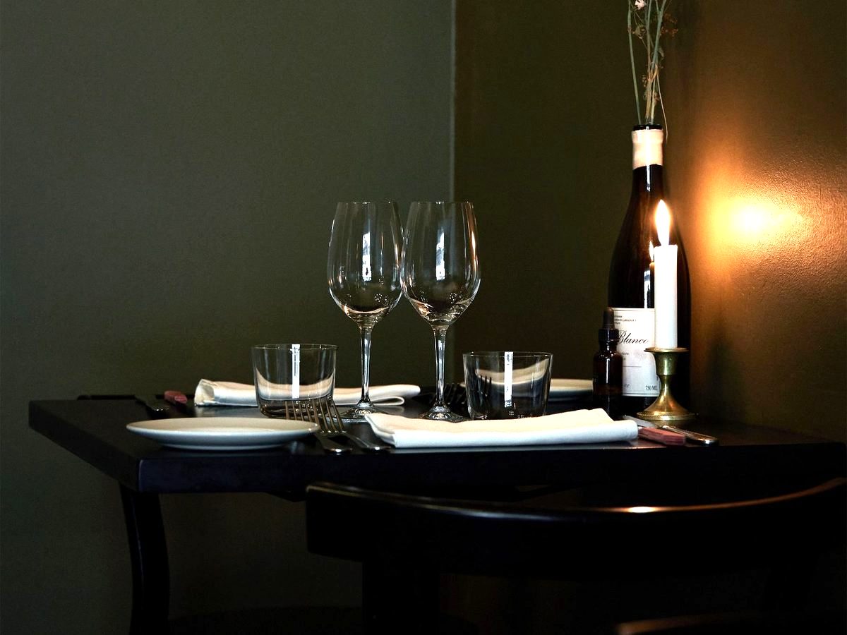 A candlelit corner table set for two
