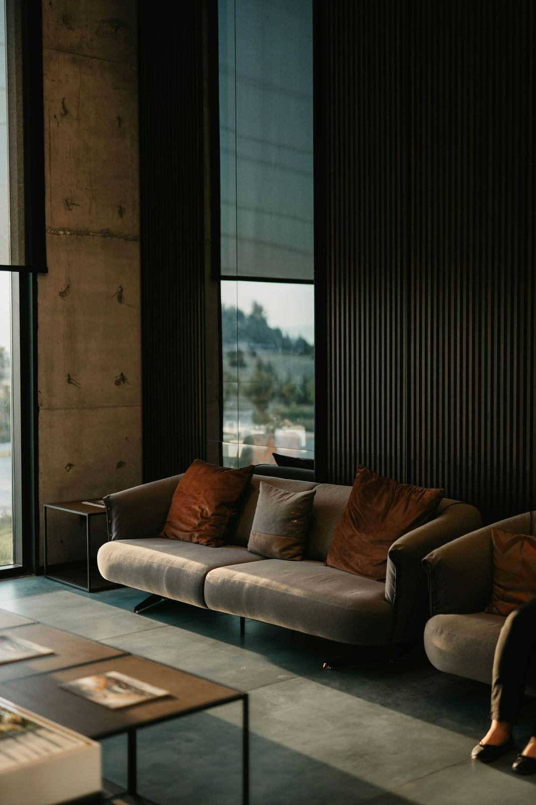 Dramatic double-height living room with walnut slat walls and designer furniture