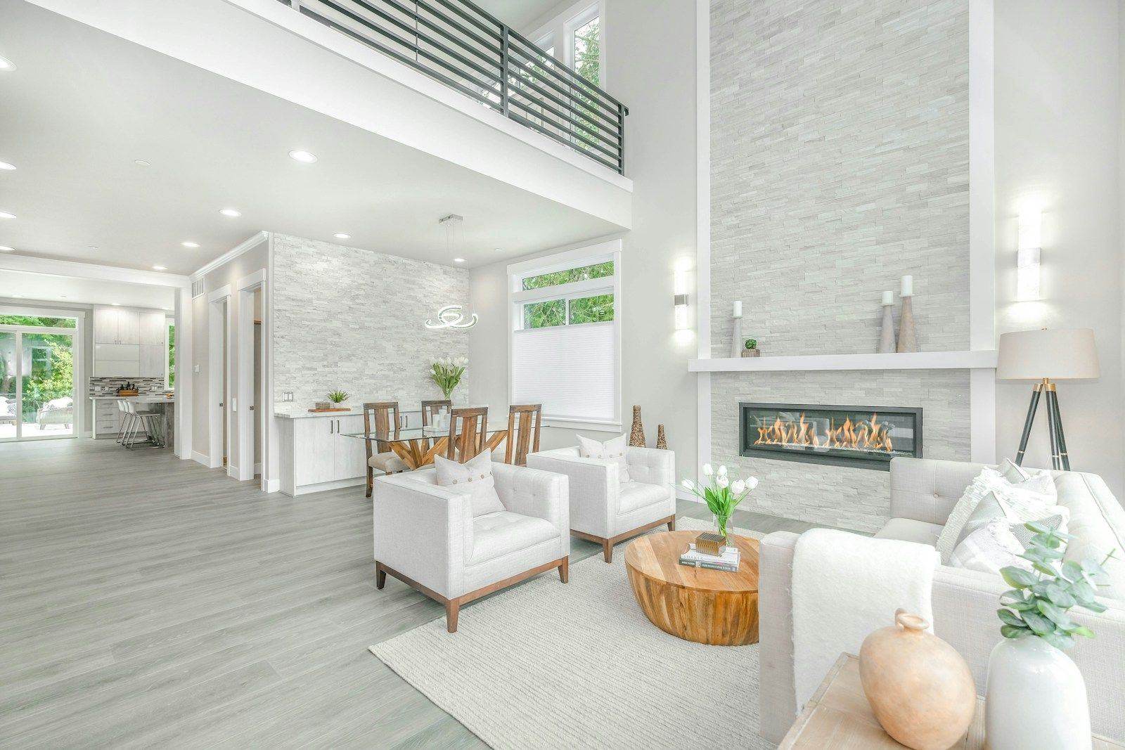 Bright two-story great room with stone fireplace and staged designer furnishings